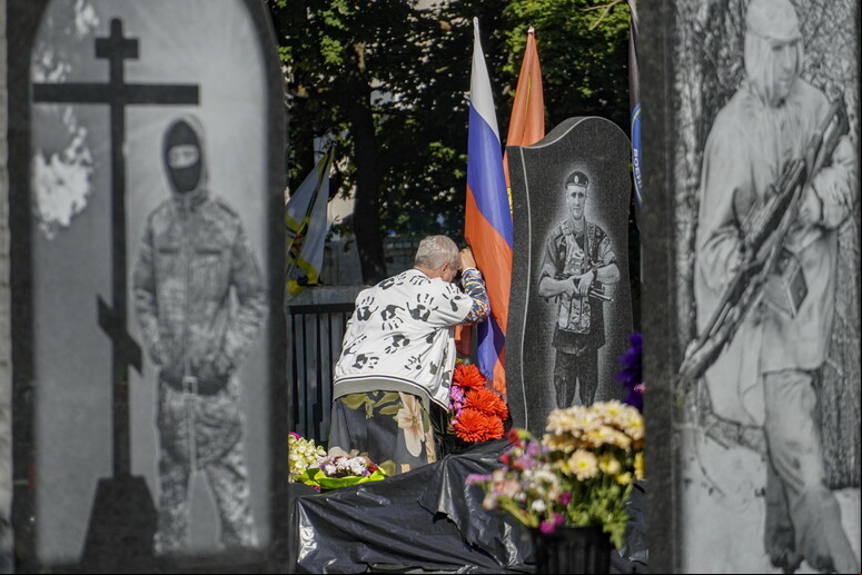 Mulher diante de túmulo de oficial russo no cemitério de Kursk © ANSA/EPA
