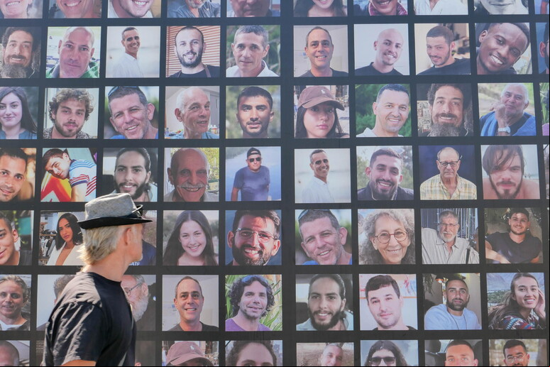 Homem observa  com fotos de reféns sequestrados pelo Hamas em Jerusalém © ANSA/EPA
