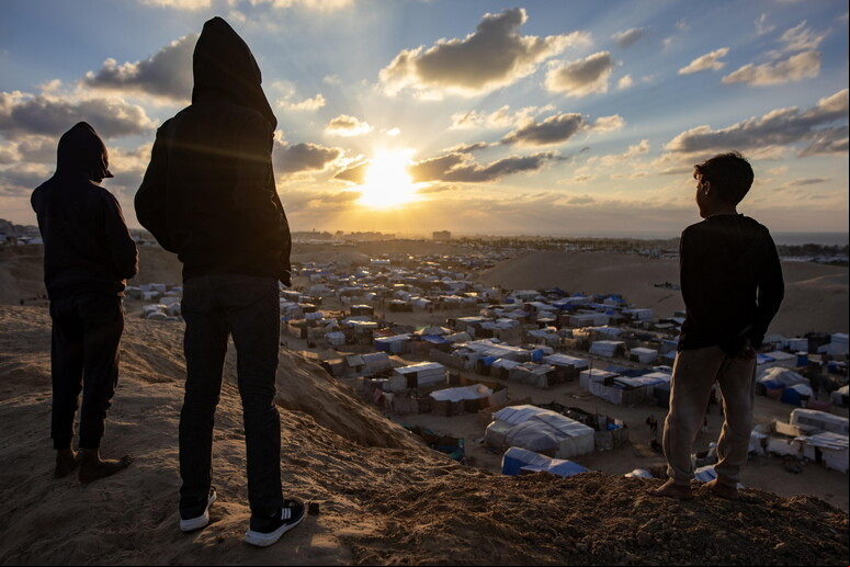 Palestinos assistem a pôr do Sol na véspera de cessar-fogo em Gaza © ANSA/EPA