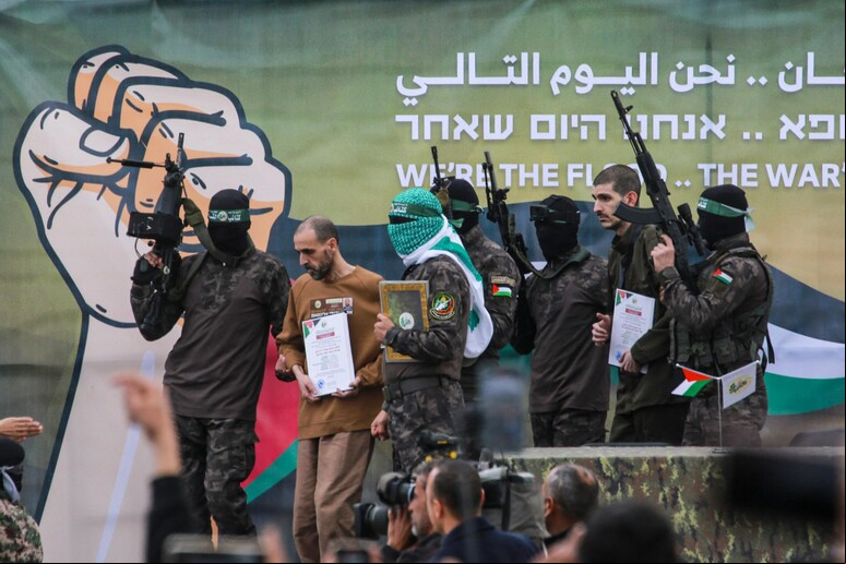 Membros do Hamas escoltando um dos reféns israelenses liberados no último fim de semana © ANSA/AFP
