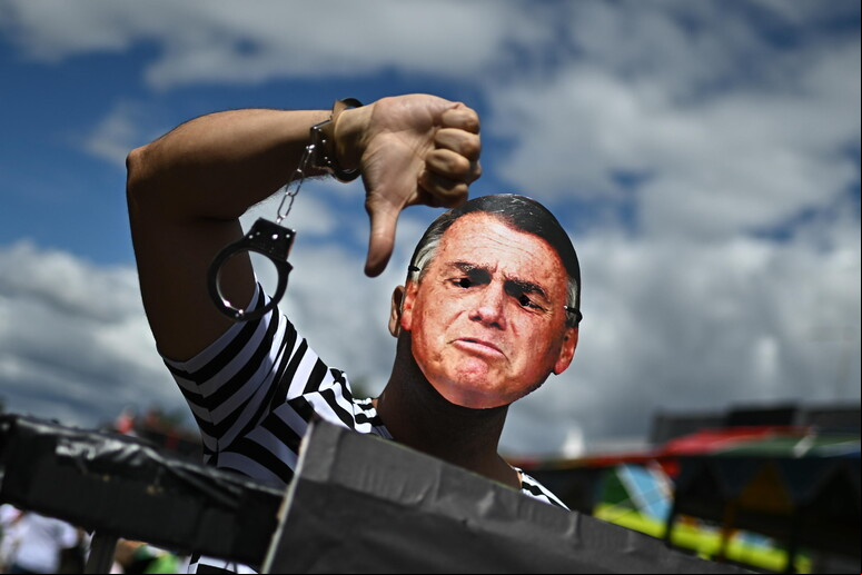Máscara com o rosto de Bolsonaro usada por folião durante carnaval © ANSA/EPA